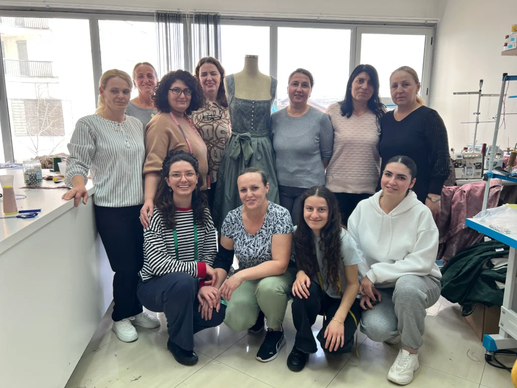 A woman sits at a table, preparing for her nail service.