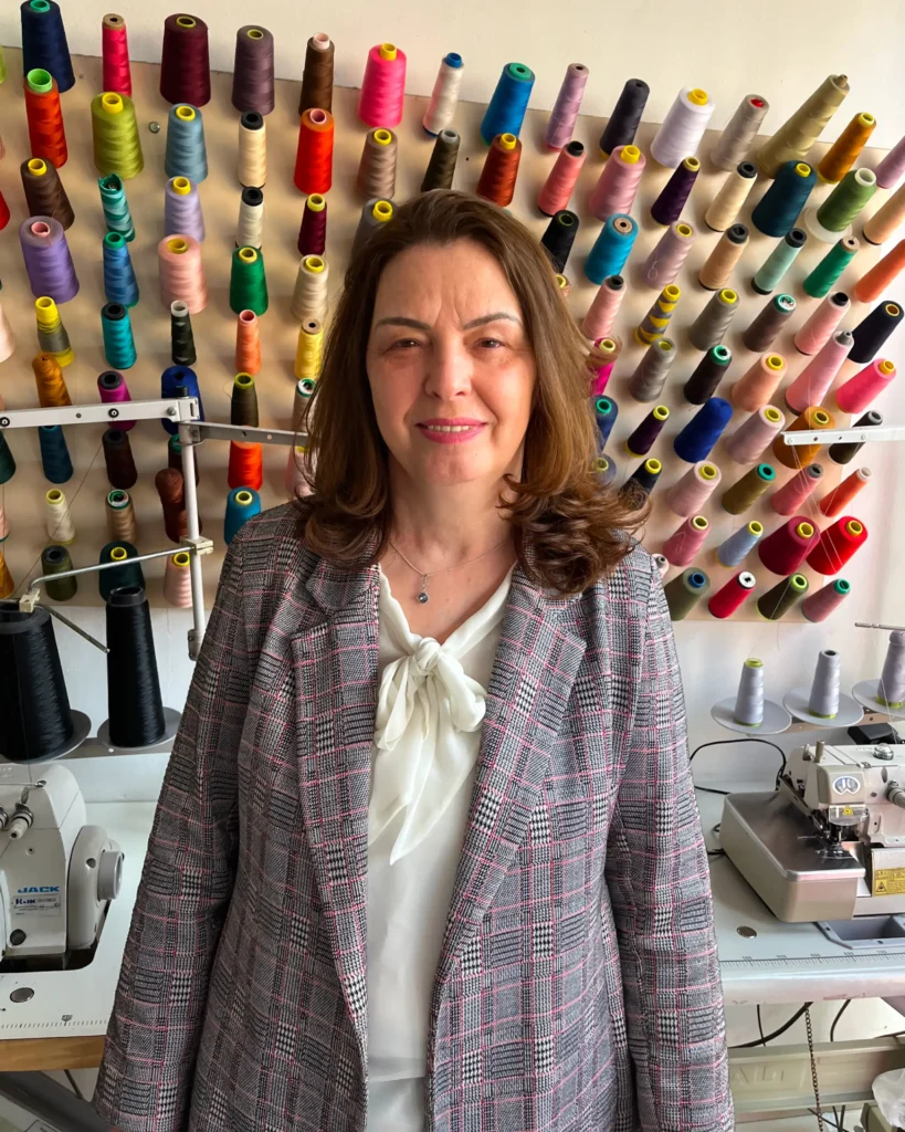 A person receiving a manicure, using a nail brush to clean and shape their nails at a nail salon